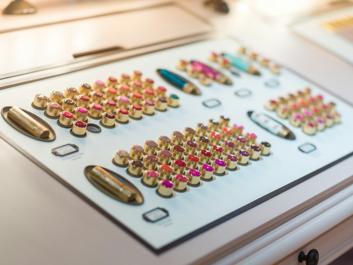 Lipstick testers arranged neatly on a white display surface.