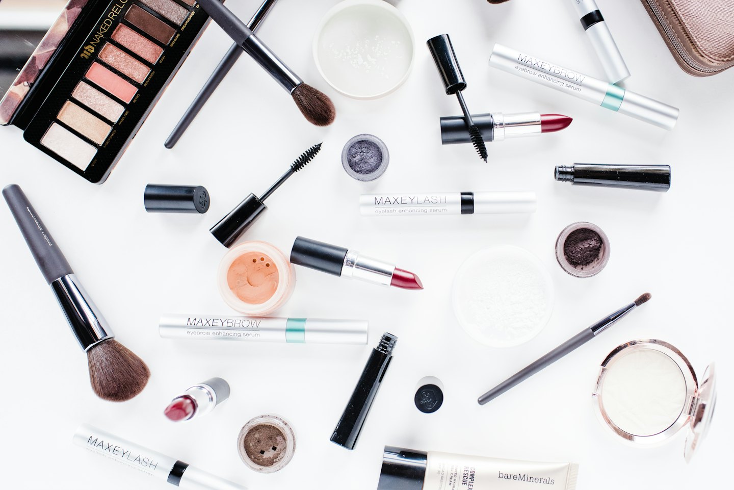 Assorted makeup products arranged on a white surface.